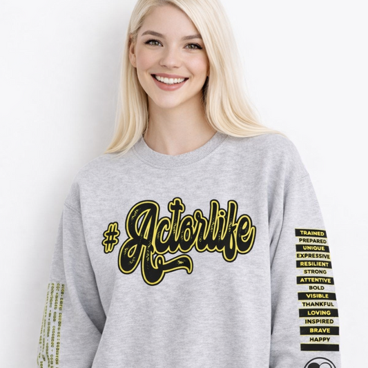 Woman wearing a gray sweatshirt with '#Actorlife' text and sleeve designs.