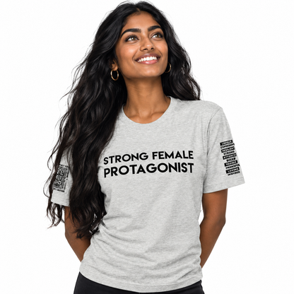 A woman with long, wavy dark hair is wearing a light heather gray t-shirt with the words 'STRONG FEMALE PROTAGONIST' printed in black across the chest. She is smiling and looking upward against a solid white background.