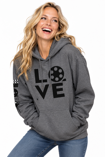 A woman wearing a heather gray pullover hoodie with a black graphic print that spells 'LOVE' using a film reel and script letters, paired with blue jeans against a white background.