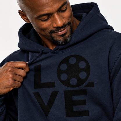 A man wearing a navy blue hoodie with a black 'LOVE' graphic on the chest, where the 'O' is shaped like a film reel. The hoodie also features film-themed graphics on the sleeve, including a clapperboard and a camera.